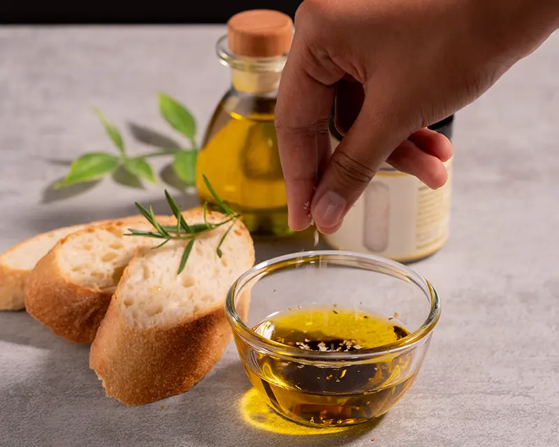 Best salt for olive oil bread dip added to olive oil with baguette and rosemary.