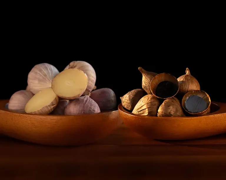 Raw garlic and black garlic showing transformation for umami salt
