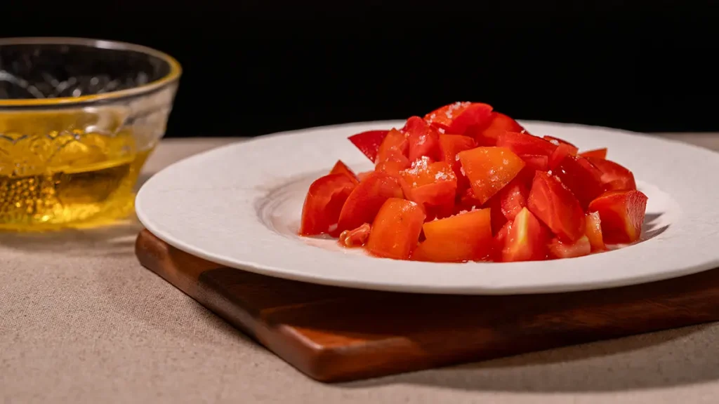 Salt crystals on sliced tomatoes, showing why the answer to do all salts taste the same changes when salt stays on the surface of food.