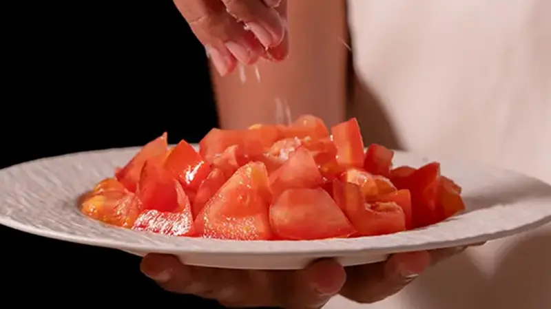 Does salt smell? Salt being added to tomatoes to show how salt brings aroma and moisture to the surface.
