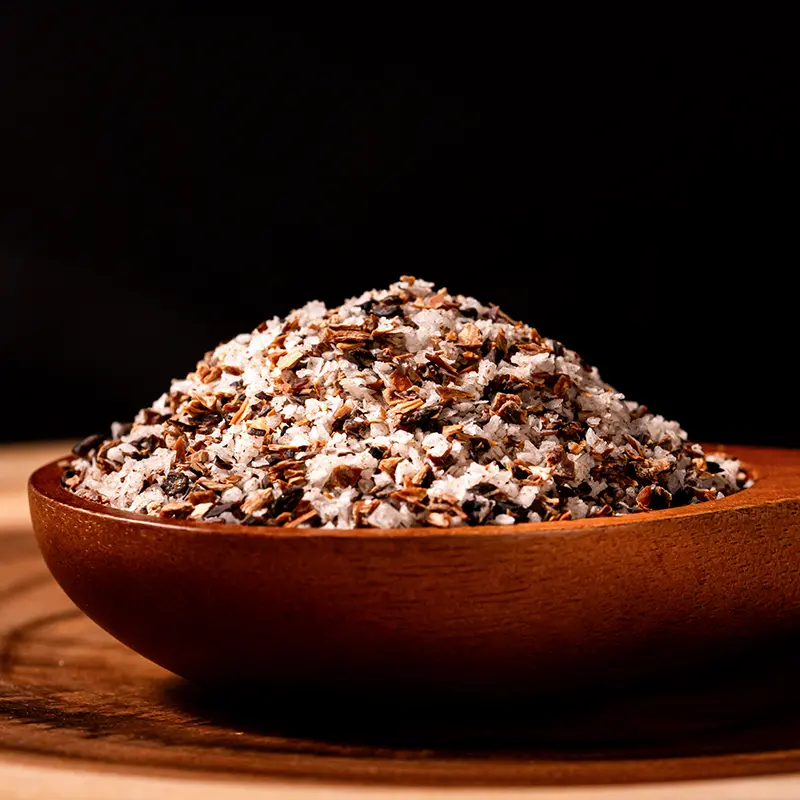 Fermented mushroom salt in a wooden bowl with visible mushroom pieces