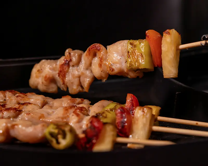 Chicken skewers browning on a hot surface, showing how salt affects flavour by changing surface moisture so food browns instead of steams.