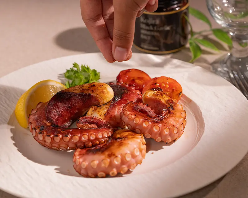 How to salt grilled octopus during the final salting moment while it is still warm