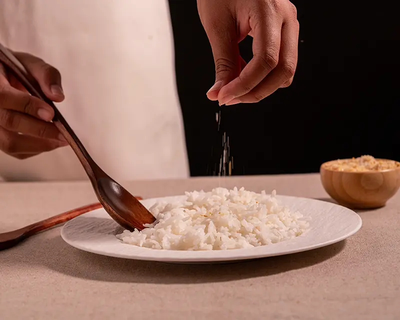 How to salt rice with finishing salt after the grains are fluffed.