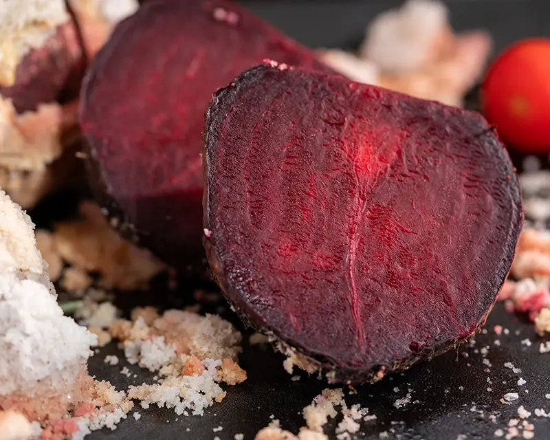How to season beets with salt-baking, showing the deep red interior of a beet after the salt crust is cracked open.