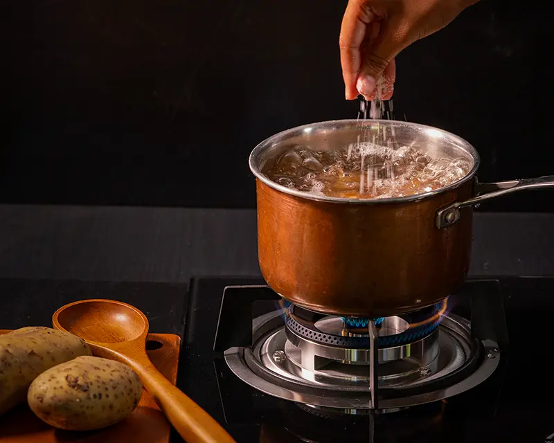 How to season boiled potatoes by adding salt to the cooking water.
