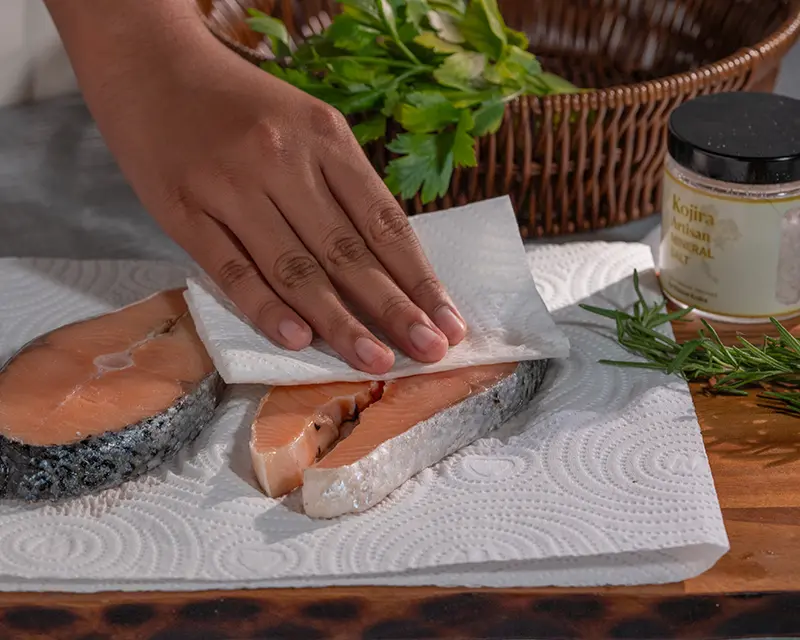 How to season salmon by patting salmon steaks dry before cooking.