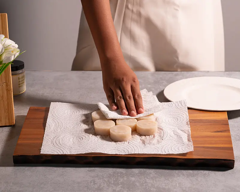 Patting scallops dry before seasoning and searing for a crisp golden crust.