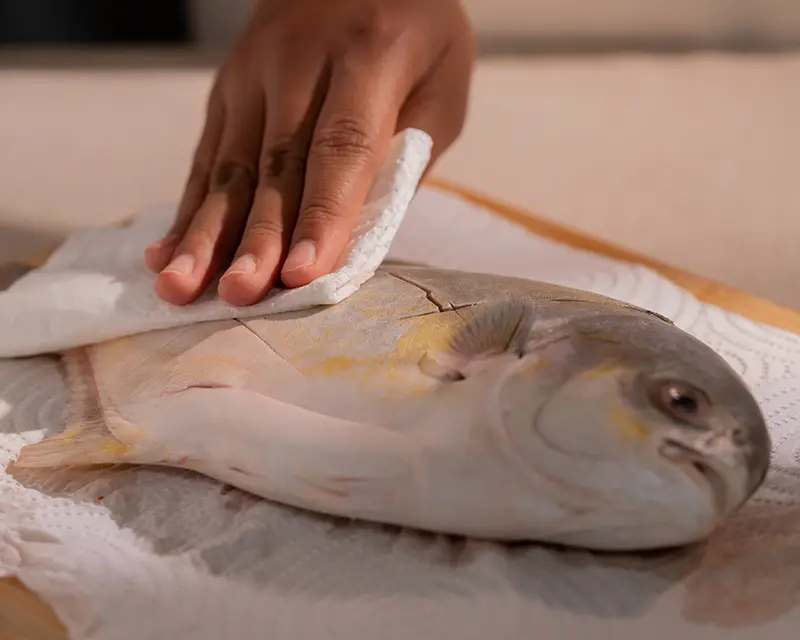 How to season whole fish by drying the scored skin before cooking.