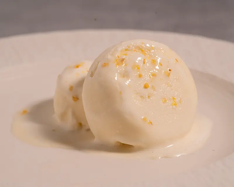 Salt on desserts with melting ice cream and citrus salt on a white plate
