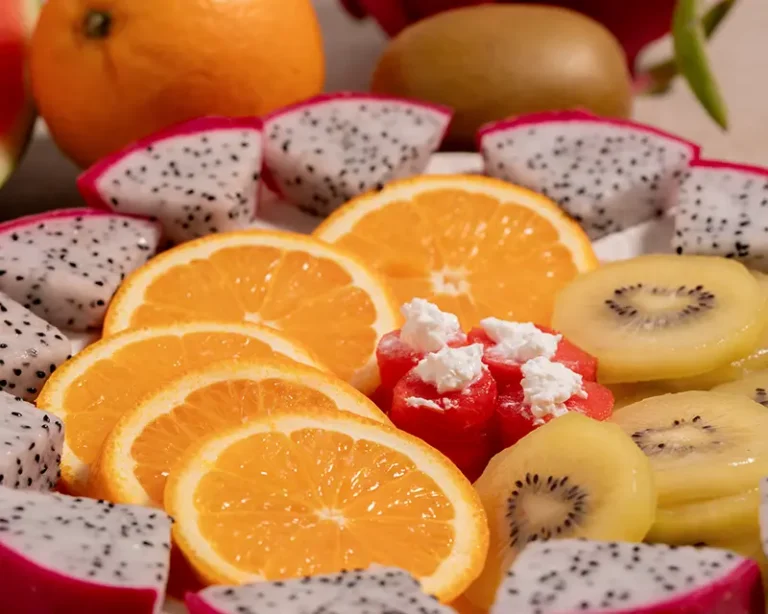 Salt on fruit with mixed fruit platter of orange, dragon fruit, kiwi and watermelon