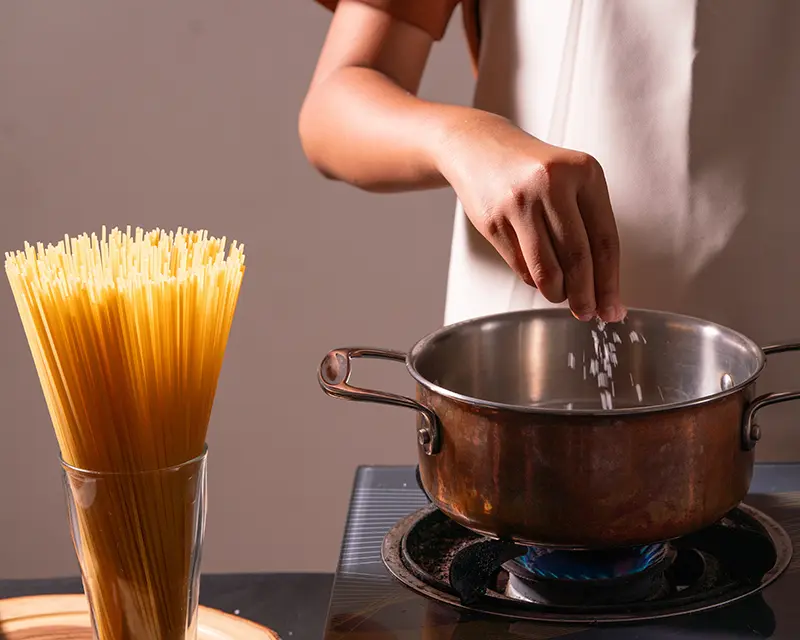 Salt being added to pasta water before cooking