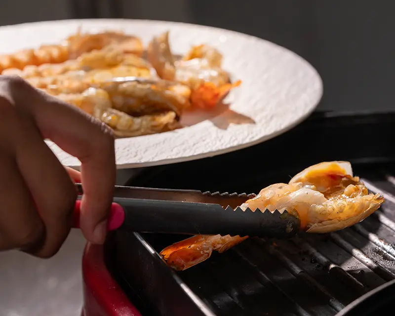 When to salt shrimp: transferring grilled butterflied tiger prawns from the grill to the plate