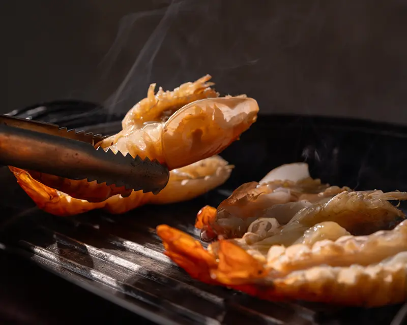 When to salt shrimp: butterflied tiger prawns grilling until pearly, opaque and juicy