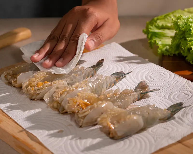 When to salt shrimp: patting butterflied tiger prawns dry after salting and before grilling
