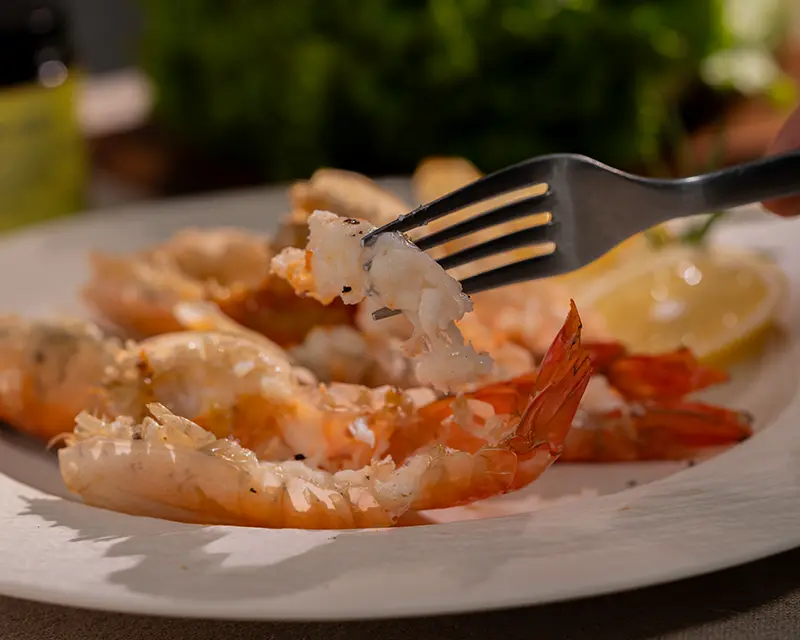When to salt shrimp: tasting a hot grilled butterflied tiger prawn by hand