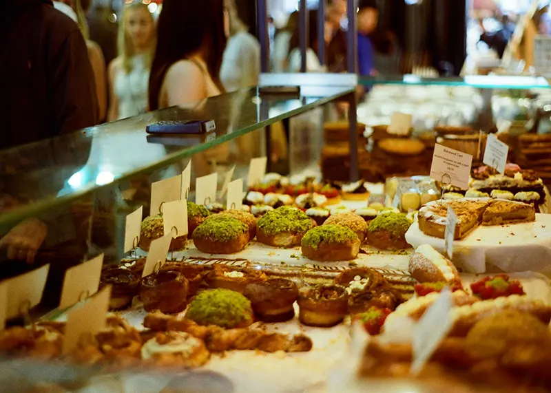 Pastries and speciality foods displayed in a lively premium food hall, illustrating wholesale gourmet food opportunities for Maison Kojira.
