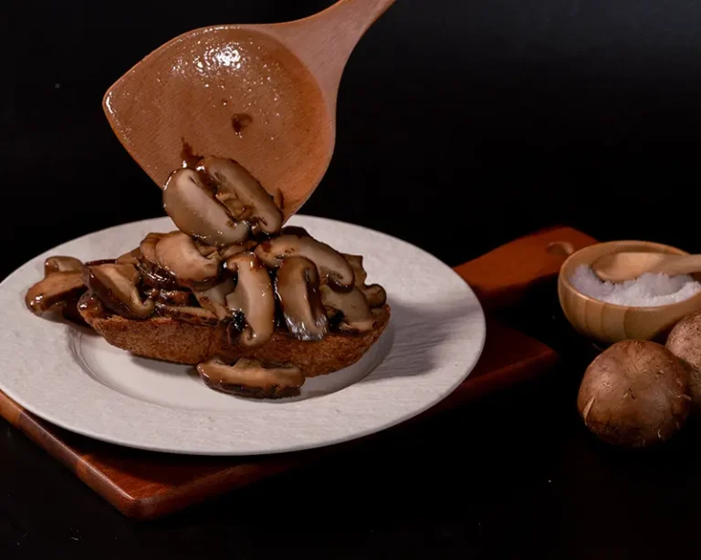 Cooked mushrooms on toast with salt, showing why salt makes food taste better by amplifying umami.