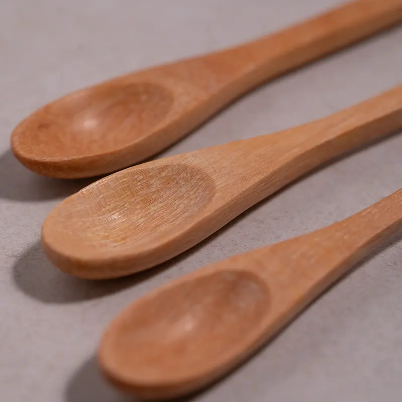 Three handmade wooden salt spoons showing the natural wood grain